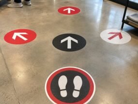 Custom directional and foot-position floor graphics installed on polished concrete
