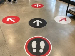 Custom directional and foot-position floor graphics installed on polished concrete